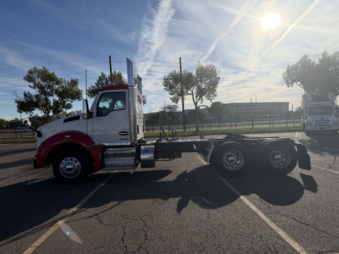 Kenworth T880 chassis viewed in side profile, blue sky, white and red cab, dual rear axles, no body panels on trailer, VIN label not visible.