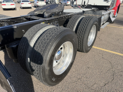 Kenworth T880 chassis showing dual rear axles with heavy-duty tires and wheel rims, fifth wheel and frame rail visible.