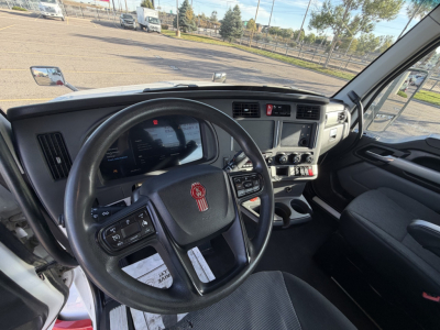Kenworth T880 truck interior view showing steering wheel and dashboard with infotainment display and controls.