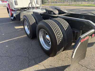 Kenworth T880 rear chassis with dual rear axles and tires showing wheel rims and mud flaps.