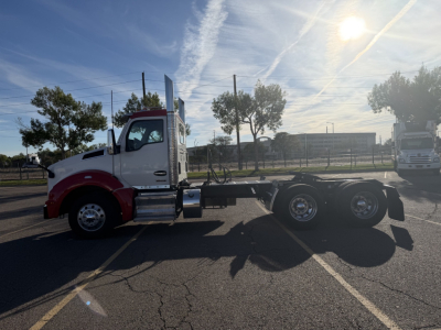 Kenworth T880 chassis viewed in side profile, blue sky, white and red cab, dual rear axles, no body panels on trailer, VIN label not visible.