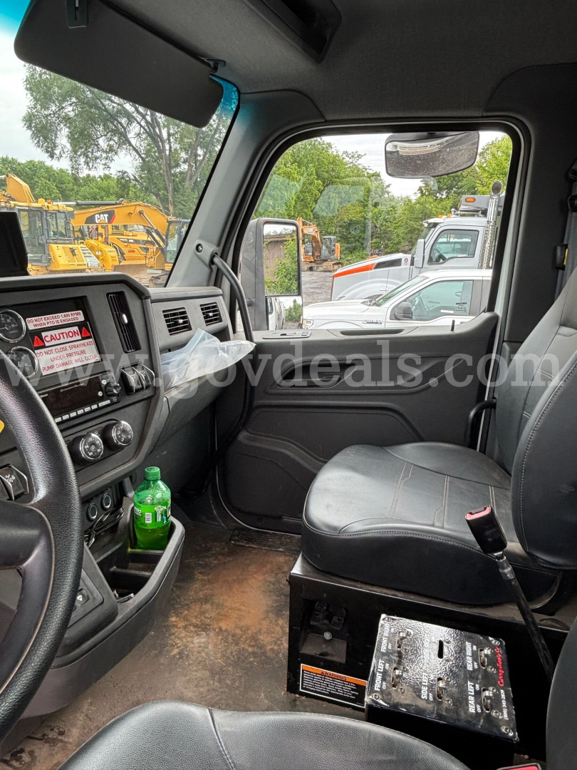 Interior of a Peterbilt truck cab showing driver seat and dashboard with control panel, bottle holder, and gear shifter.