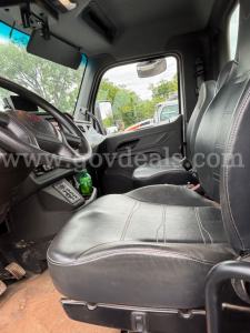 Truck cab interior showing driver seat and front passenger seat with steering wheel, dashboard, and door view in a Peterbilt tanker truck.