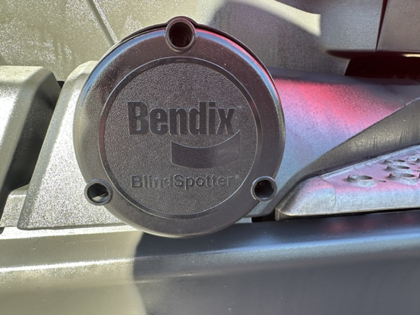 Kenworth truck component showing Bendix BlindSpotter sensor cap with embossed Bendix logo on round cover.