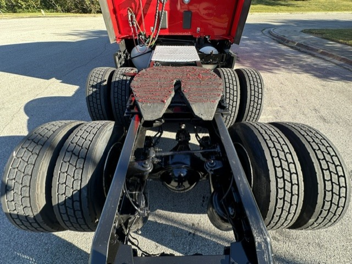 Kenworth T680 chassis and fifth wheel area showing dual rear axles and dual tires from rear angle.