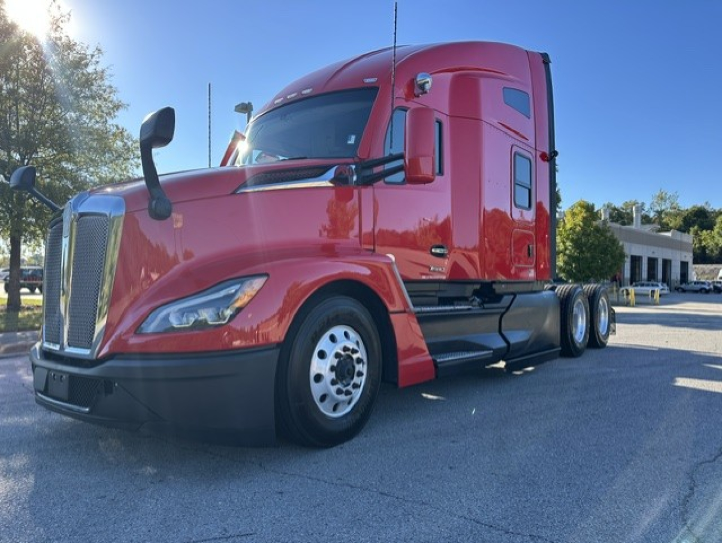 Kenworth T680 conventional sleeper truck in red, front three-quarter view, showing cab, front grille, headlights, and dual rear axles.