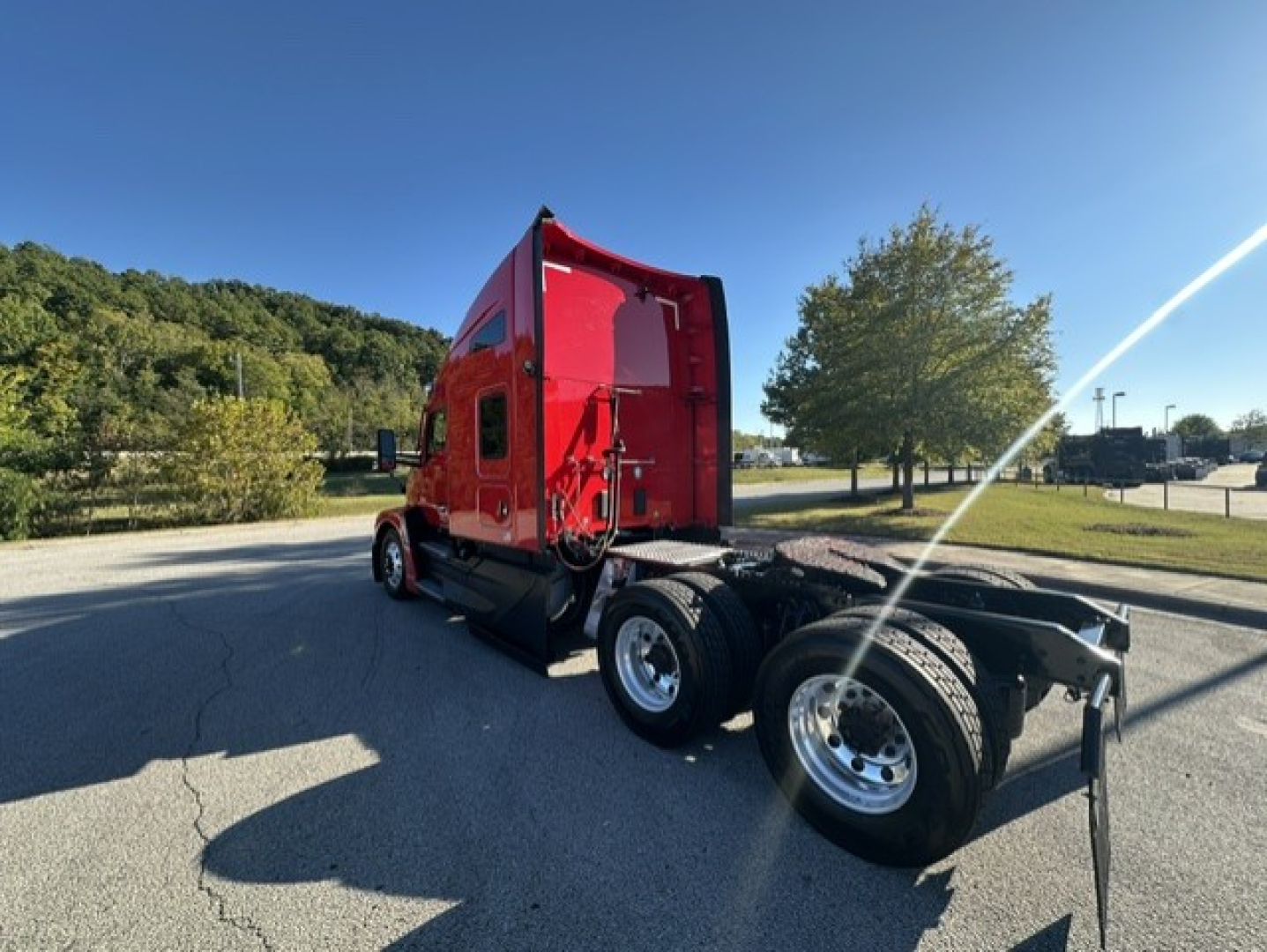 Kenworth T680 truck cab and chassis in red, side view showing sleeper cab and rear dual wheels, no trailer attached.