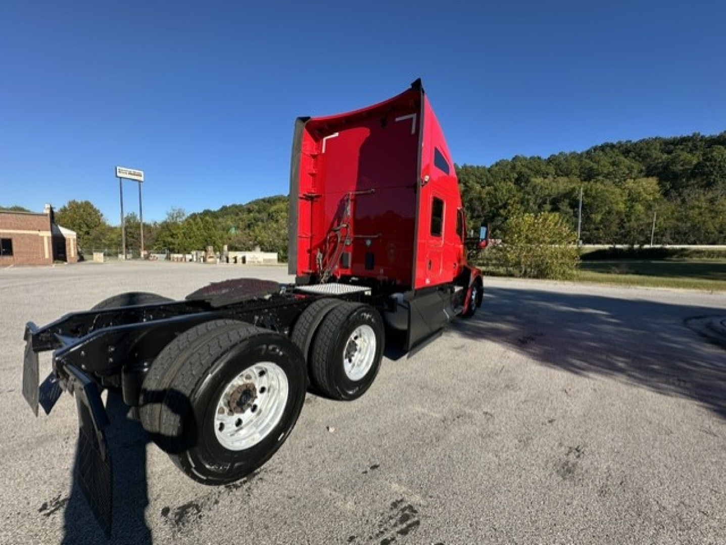 Kenworth T680 truck chassis and cab in red seater with dual rear axles, rear view showing fifth wheel and wheels, 2023 model identification not visible.