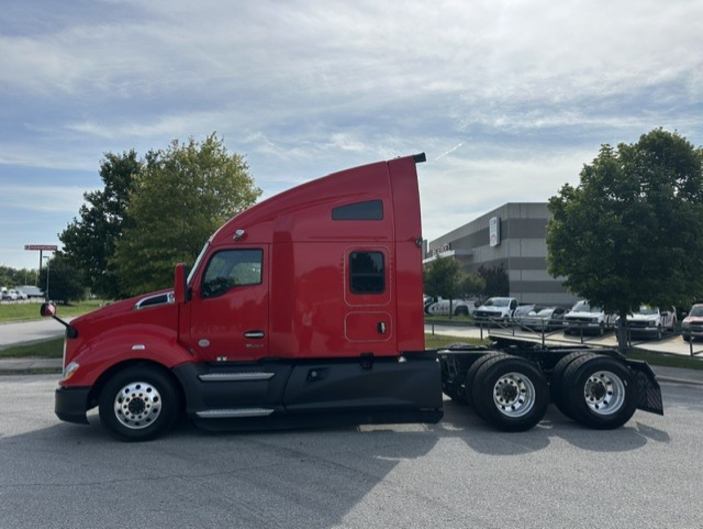 Kenworth T680 heavy-duty truck side view showing red cab and rear-axle configuration with sleeper, chrome wheels, and multiple axles.