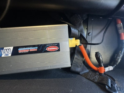 Kenworth T680 electrical/auxiliary battery box with yellow plug and orange wiring visible