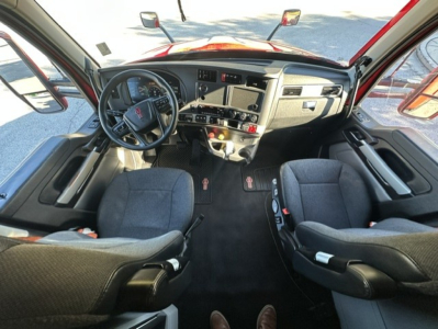 Kenworth T680 truck cabin interior with steering wheel, dash, and two front seats visible.