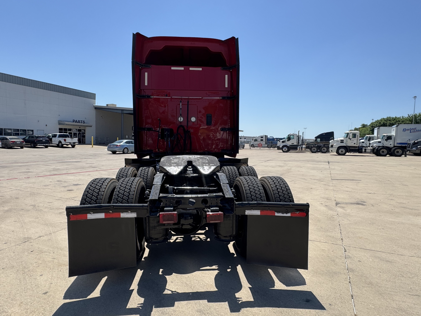 Truck rear view showing fifth wheel and dual rear axles of a red 2022 International LT conventional sleeper.