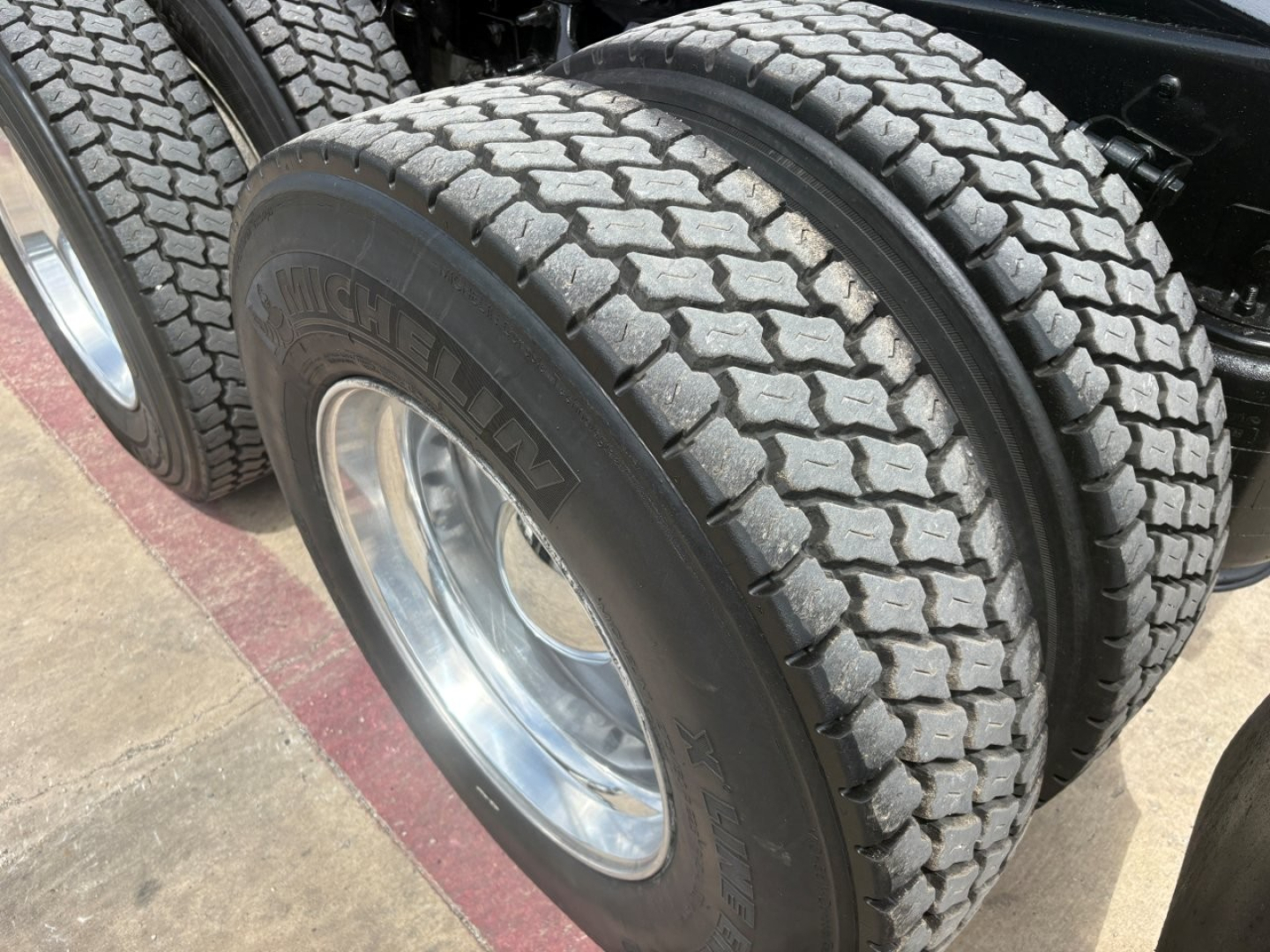 Dual rear tires showing Hankook brand tires on a truck axle with chrome rims.