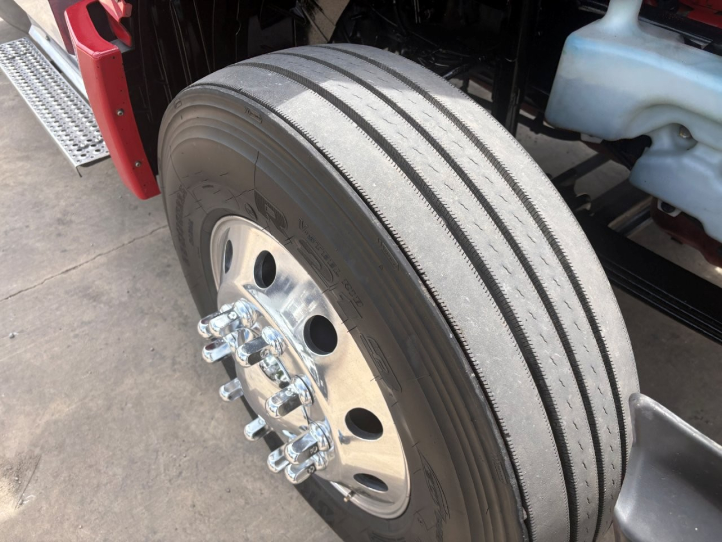 Truck wheel/tire assembly with dual rear axles showing tread pattern and steel hub, part of a 2022 International LT in a sleeper configuration.