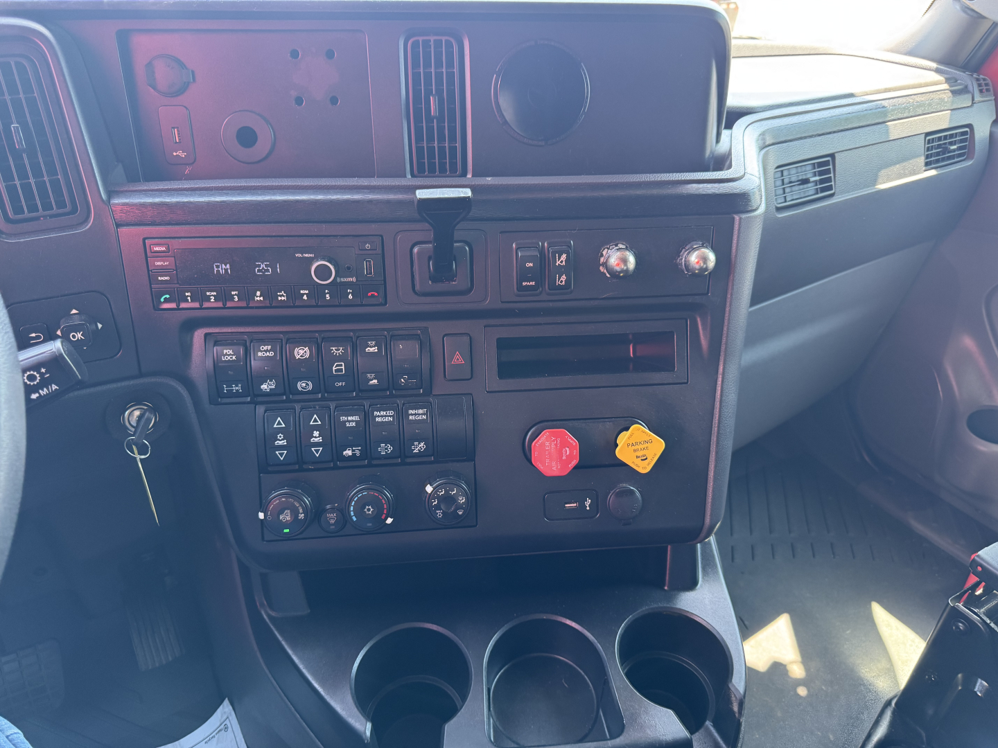 Cabin dash of a 2022 International LT showing instrument panel, climate controls, and cupholders.