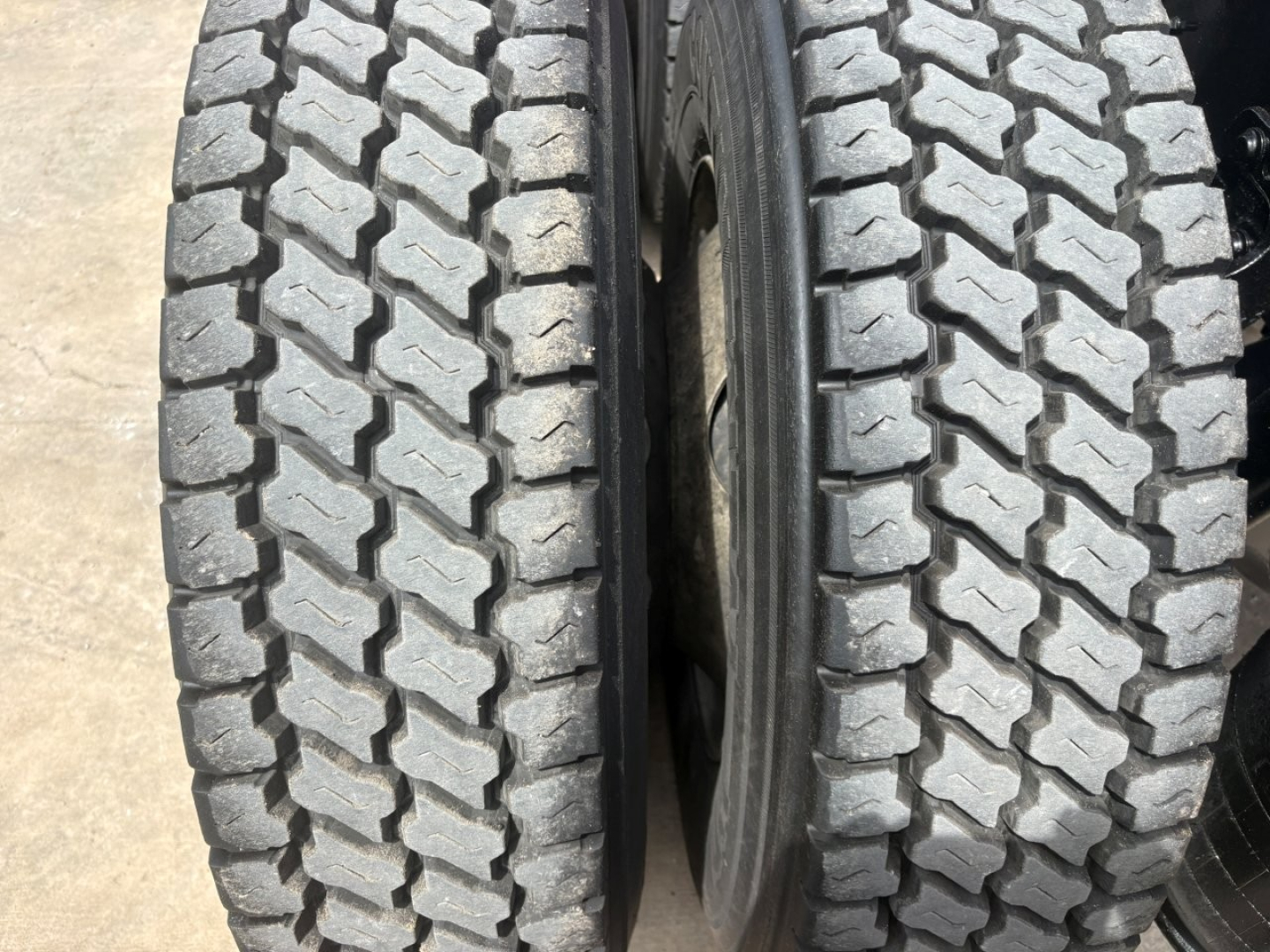 Truck dual rear tires showing tread pattern and wheel rims.