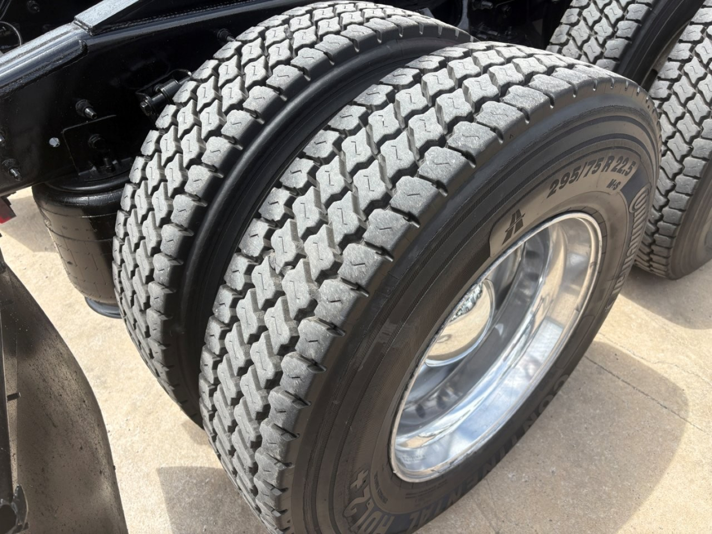 Truck tandem axle tire close-up showing dual rear wheels and tread pattern.