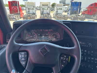 Interior view of a 2022 International LT truck from the driver’s seat, showing the steering wheel with Integrated controls and the instrument cluster, dashboard, and infotainment panel.