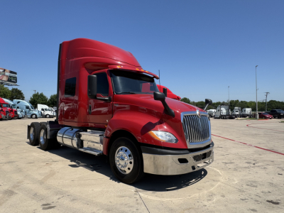 International LT truck cab in red, front three-quarter view with sleeper, chrome bumper and dual rear axles.