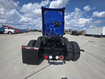 Kenworth T680 rear view showing fifth wheel, dual rear axles, and taillights with clearance lamps in a truck yard.