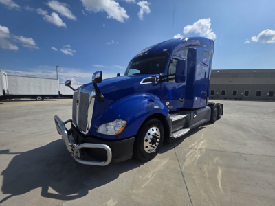 Kenworth T680 truck in blue, front-left view showing chrome bumper guard and sleeper cab with side mirrors.