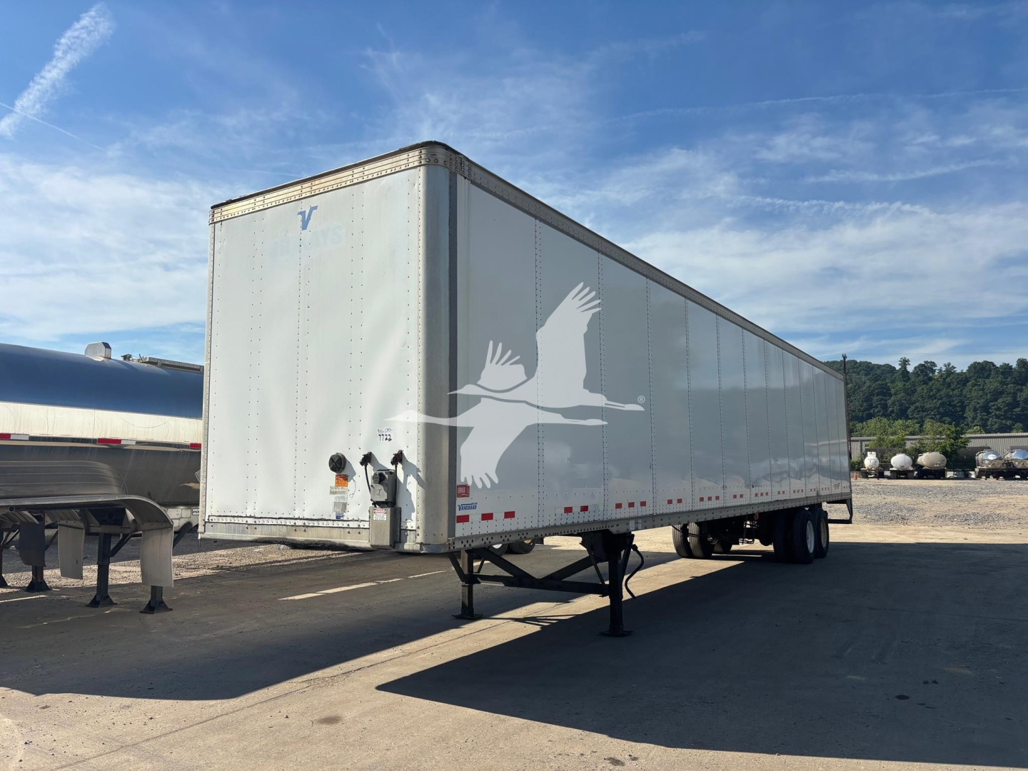 Trailer showing Vanguard VXP logo on front left and side; visible wheel area and support legs; VIN 5V8VC5327HM701806 on listing; white box trailer.
