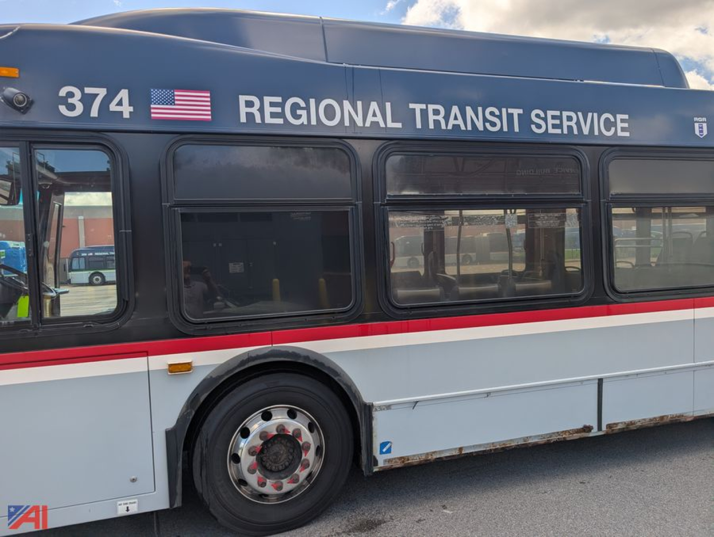 Transit bus side showing Regional Transit Service branding, bus number 374, American flag, XD60 style body, red and white stripe.