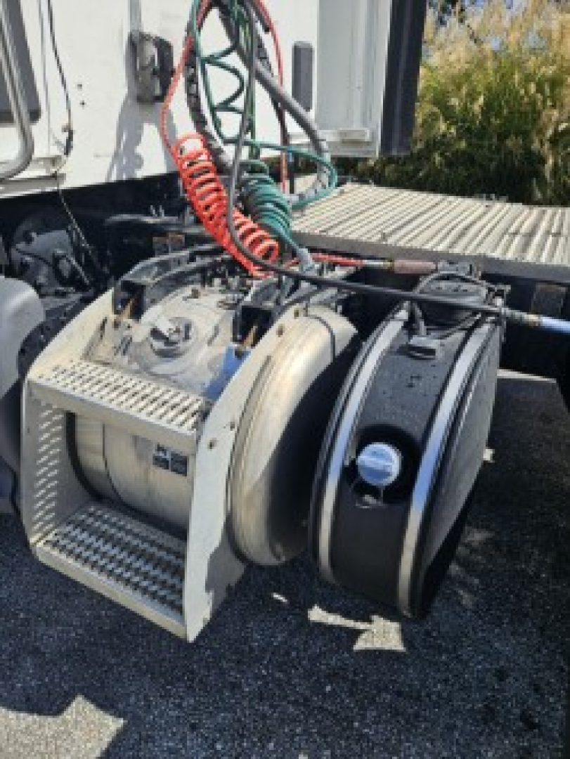 Peterbilt 579 truck engine bay with exhaust hoses and air filtration system visible.