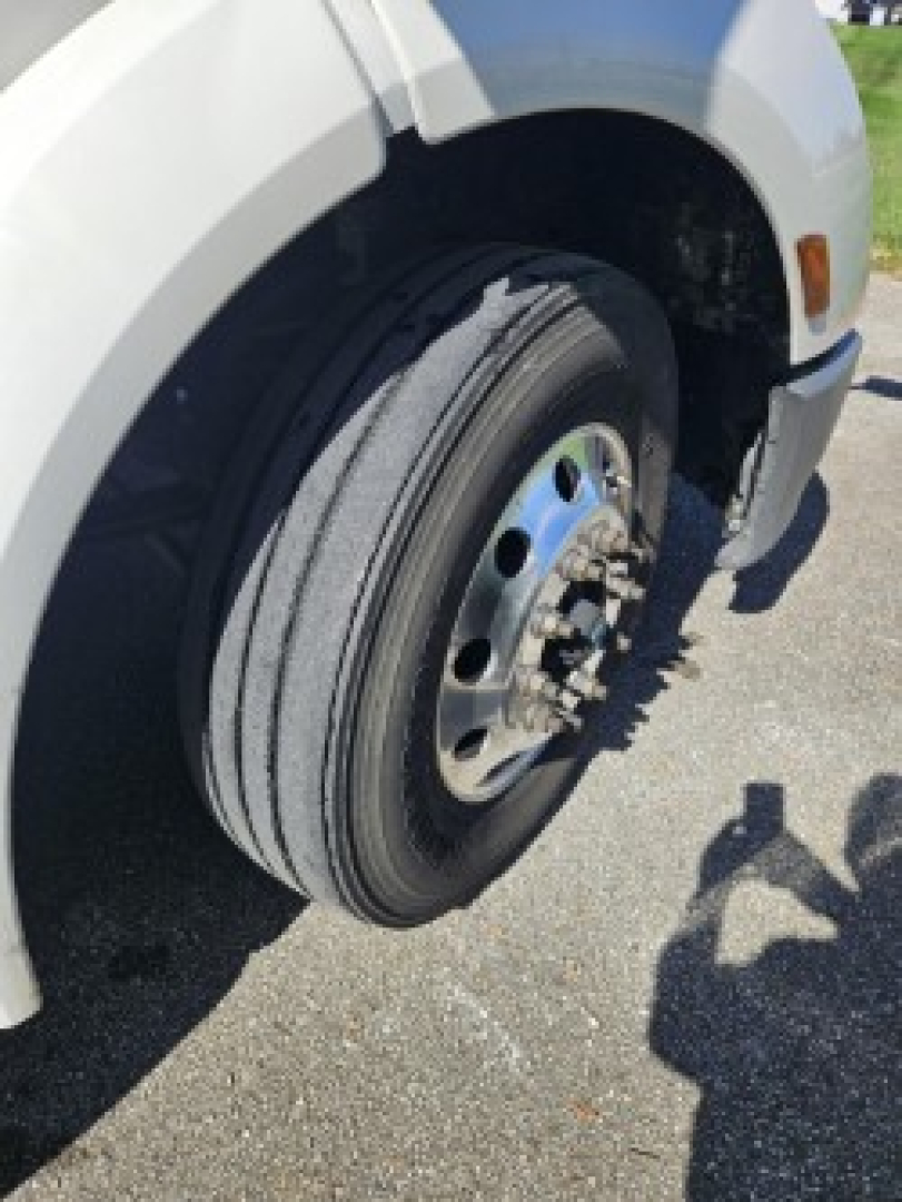 Front wheel and fender view of a 2021 Peterbilt 579 conventional daycab showing wheel, tire, and hub with text not visible.