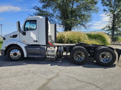 Peterbilt 579 daycab chassis side view showing cab, fuel tanks, and rear axles.