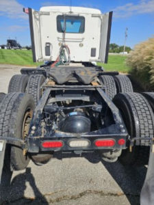 Peterbilt 579 tractor rear view showing fifth wheel, dual rear axles, and dual tires with drivetrain components visible.