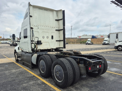 Truck chassis and cab of a 2023 International LT625 tractor from rear-left view, showing tandem rear axles and fifth-wheel area.