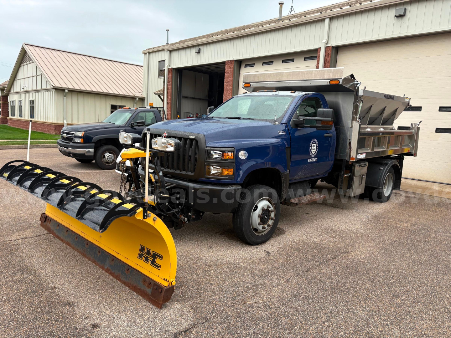Blue 2020 International CV515 dump truck with a yellow snow plow attachment in front, steel dump bed, front grille, and logo on door; VIN 1HTKTSWM4LH884541.