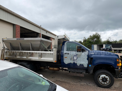 International CV515 dump truck in side view showing dump bed, cab with blue paint, and wheeled front. Visible text on door and truck body.