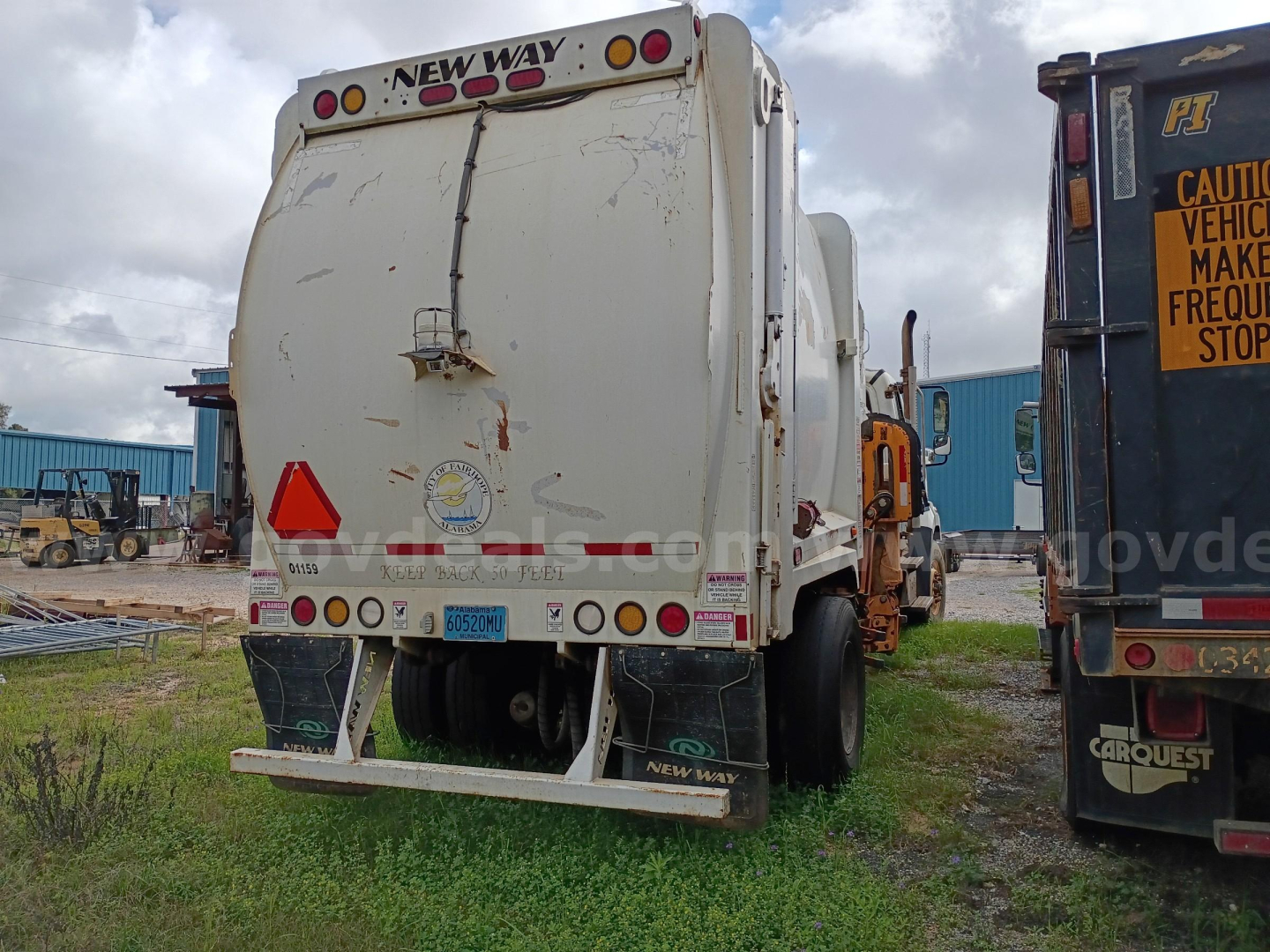 Rear view of a Freightliner 114SD refuse truck with bumper guards and lights; visible text includes 'NEW WAY' on the rear top and license plate area.