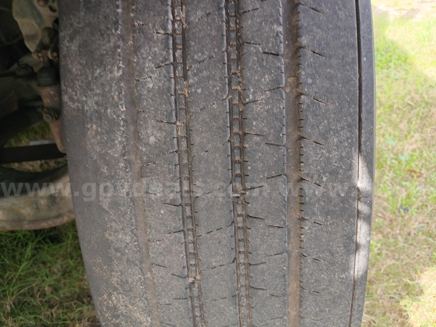 Freightliner 114SD wheel and tire tread close-up showing worn road grime on the tread and sidewall