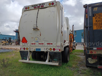 Rear view of a Freightliner 114SD refuse truck with bumper guards and lights; visible text includes 'NEW WAY' on the rear top and license plate area.