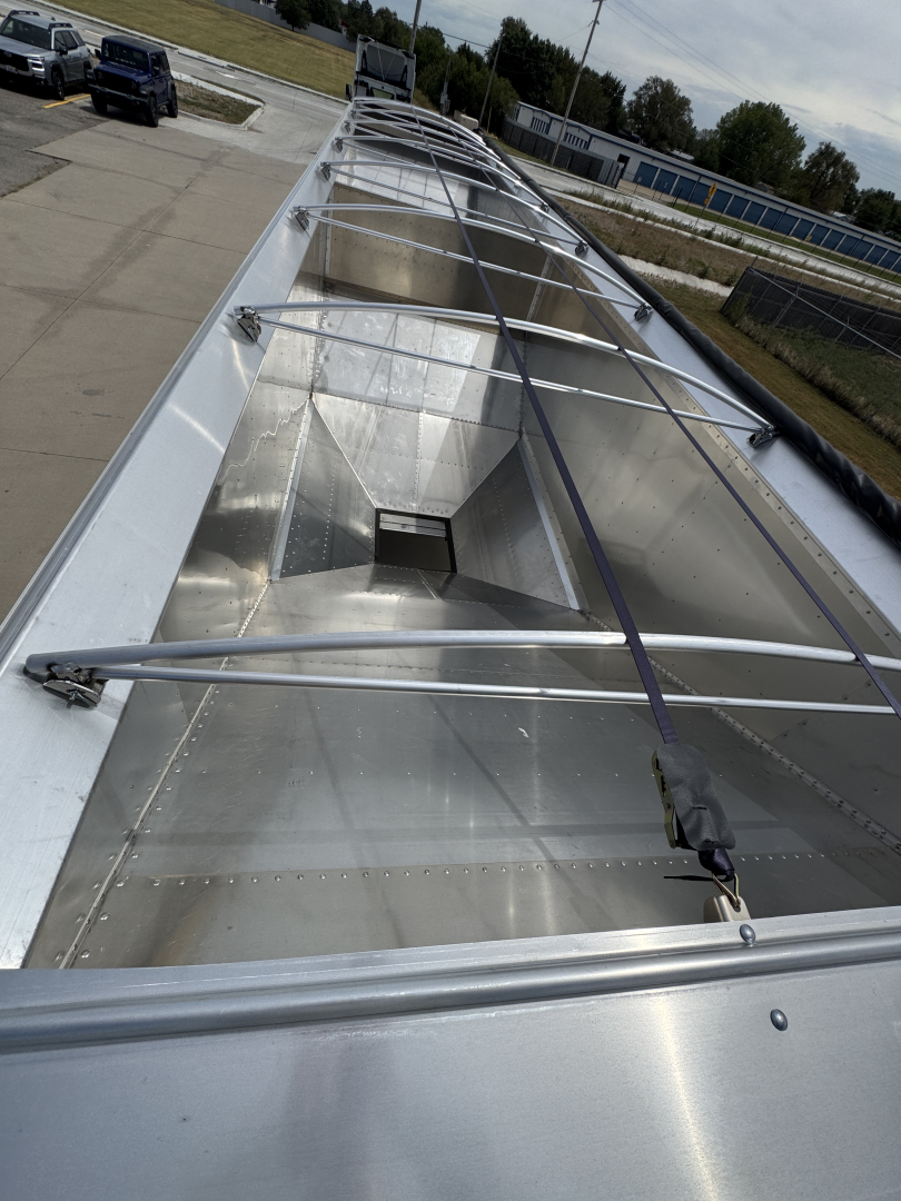 Aluminum grain hopper trailer roof view showing corrugated sidewalls and ladder framework along top edge.