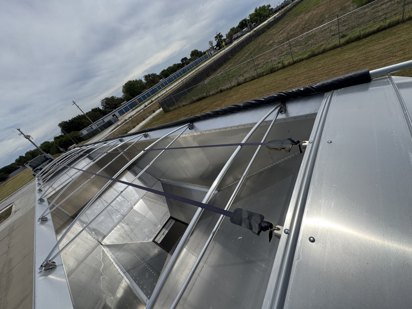 Stoughton 42' aluminum grain hopper trailer showing corrugated 74" sidewalls and metal framework on top rail.