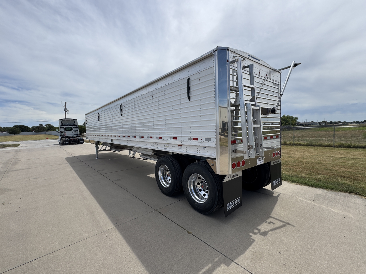 Stoughton 42' aluminum grain hopper trailer with corrugated sidewalls and dual rear axles, rear access ladder, and tail area, side profile view.
