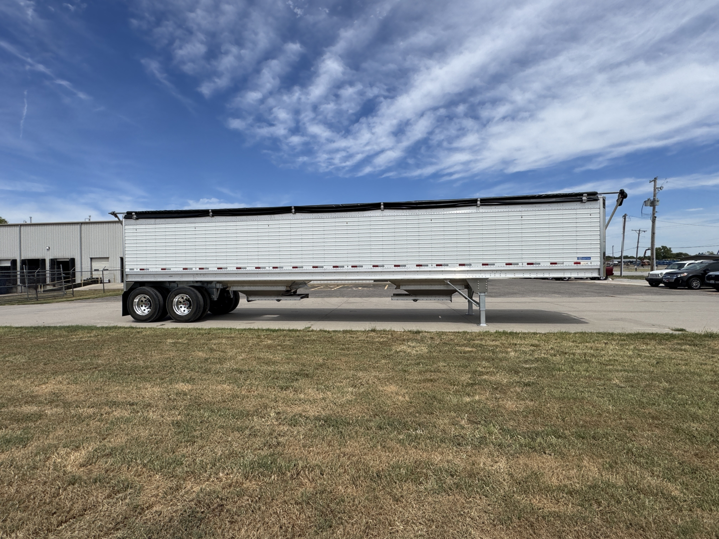 Stoughton 42' aluminum grain trailer with 74" corrugated sidewalls, tandem axles, and landing gear, shown in side view.