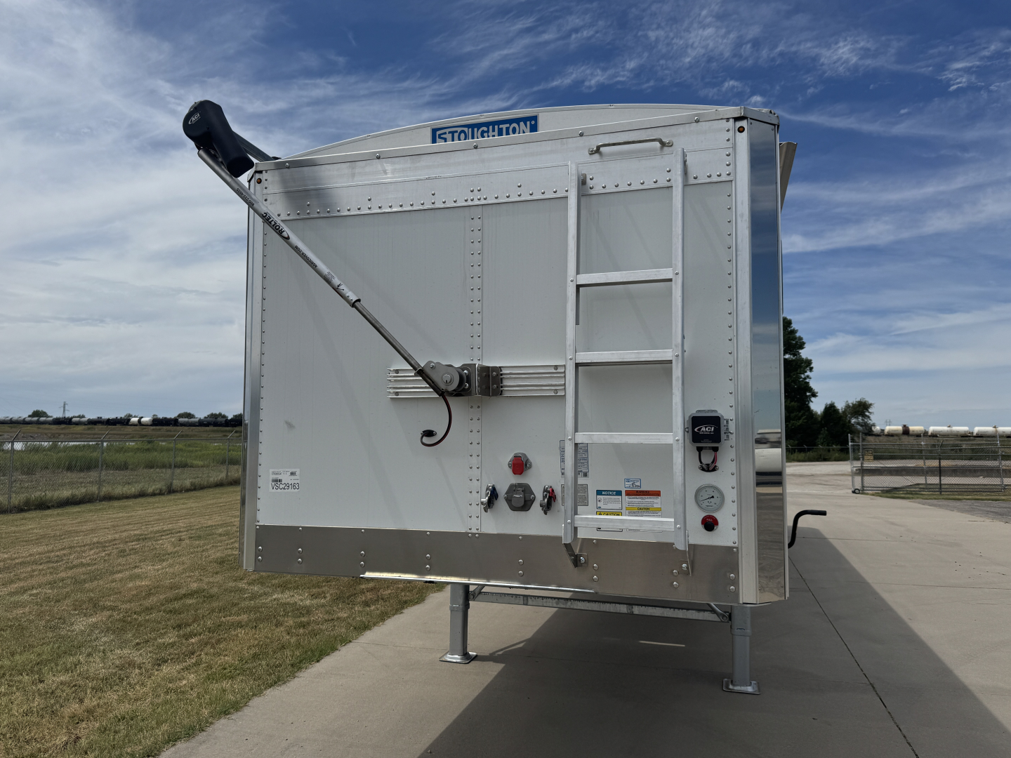 46x rear view of 2027 Stoughton 42' aluminum grain hopper trailer showing 74 inch corrugated sidewalls, rear access ladder, rear discharge auger, and landing gear.