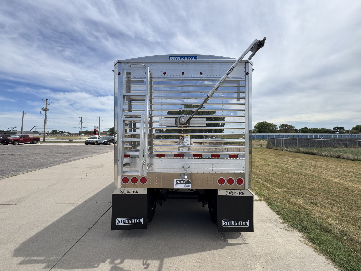 Trailer rear view of a new 2027 Stoughton 42' aluminum grain hopper with corrugated 74 inch sidewalls, polished metal exterior, and rear gates.