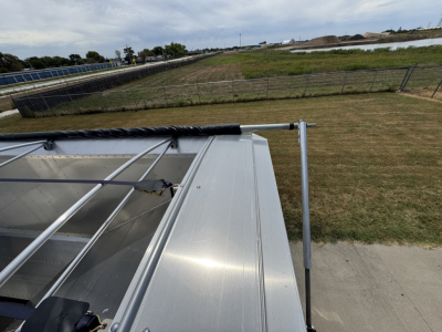 Aluminum grain hopper trailer top edge with corrugated sidewalls and railing showing 74-inch height.