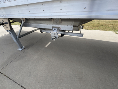 Hopper trailer undercarriage showing hitch and support legs, 74 inch corrugated sidewalls on a 2027 Stoughton 42' aluminum grain hopper.