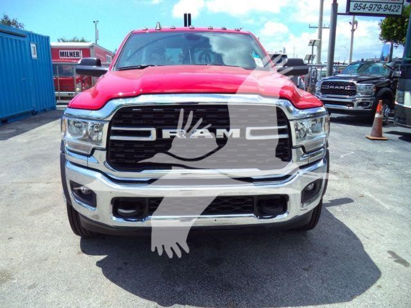 Ram 4500 front view showing large grille with RAM lettering and chrome bumper, red pickup in a dealership lot.