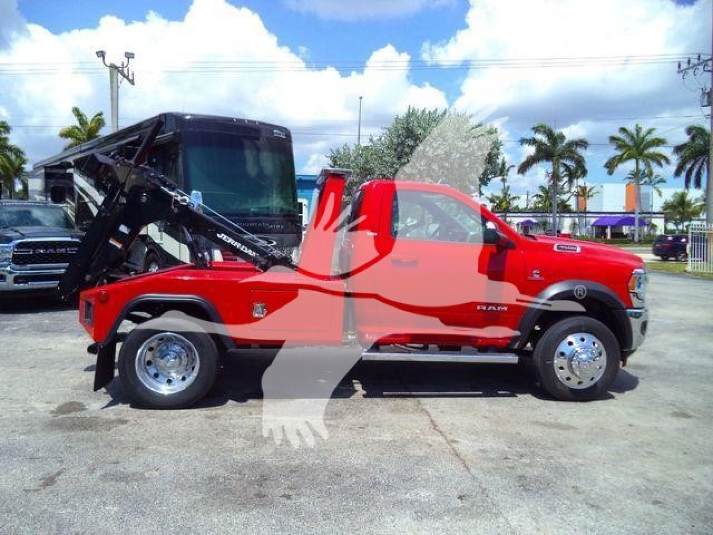 Truck bed with hydraulic tow/winch apparatus attached to red Ram 4500 SLT cab; side view showing extended wheelbase and tow mechanism.