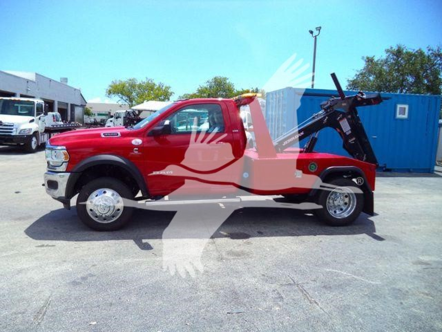 Ram 4500 SLT tow truck side view showing winch crane and lifted hoist in red pickup with black equipment arm.