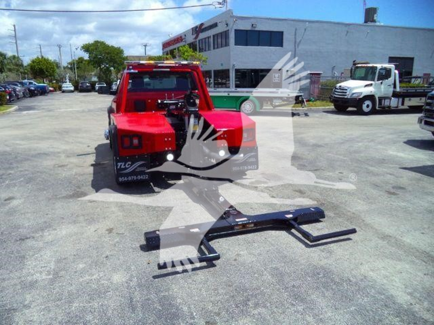 Ram 4500 SLT tow truck with winch kit resting on ground; red cab in background; front mounted winch frame and metal winch mounting brackets visible.