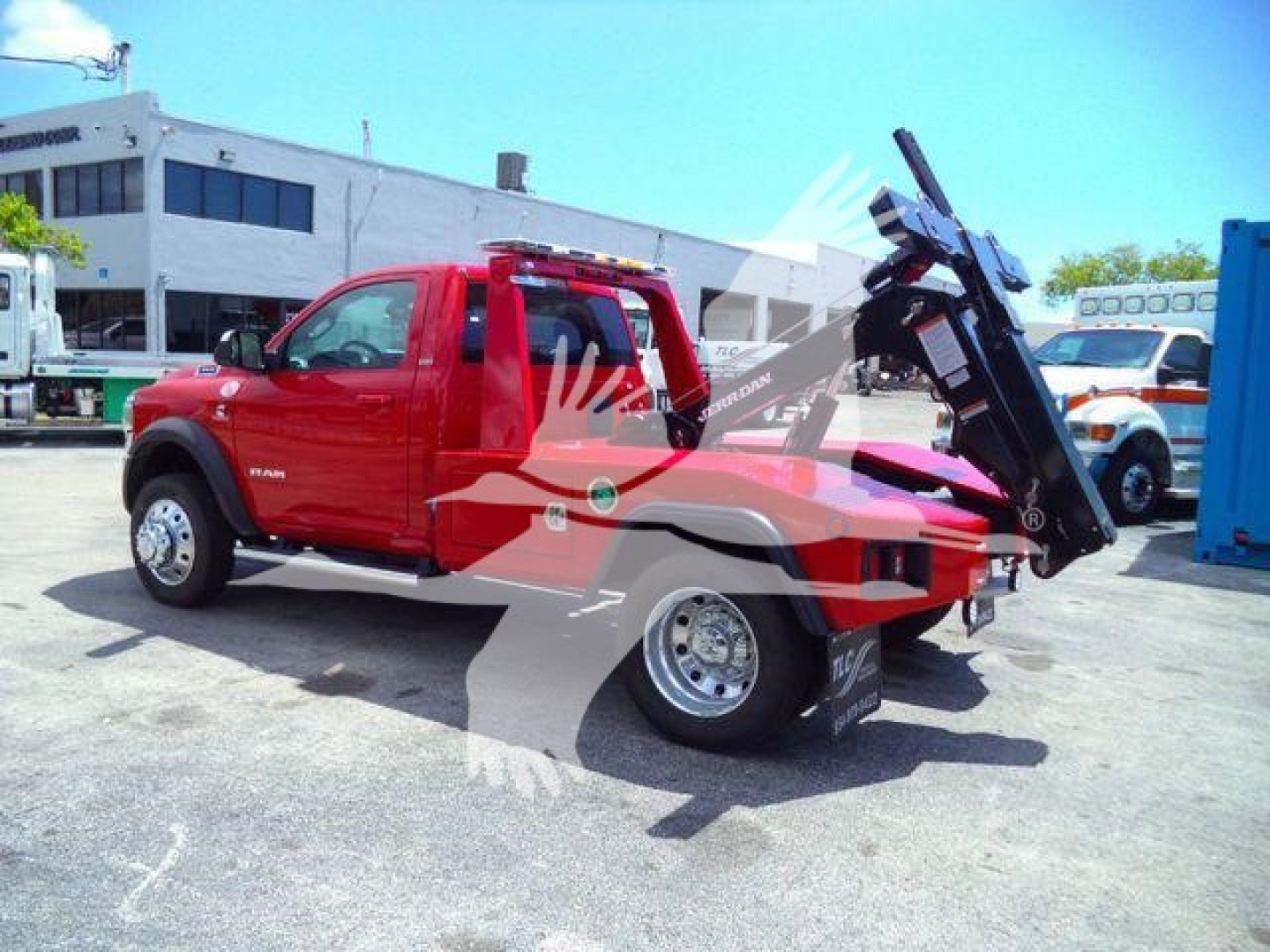 Truck bed winch feature on red 2024 Ram 4500 SLT with hydraulic tow mechanism and rear hitch, side view.